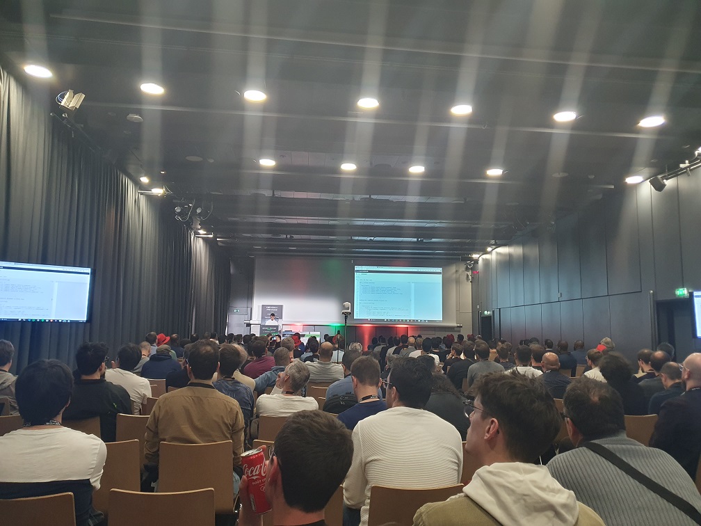 Photo de Pietro Mele faisant la démonstration d&rsquo;un système RAG sur OpenSearch Dashboards devant de nombreux participants